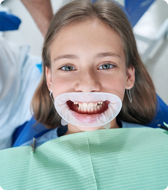 Young child smiling and showing healthy teeth