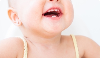 Baby with a first tooth coming through