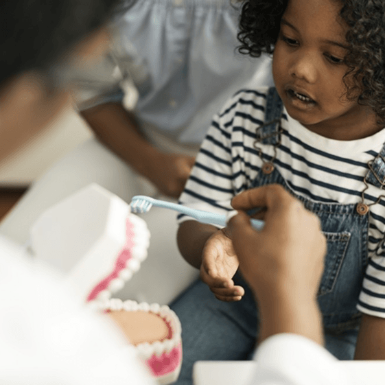 Dentist teaching a child about dental care